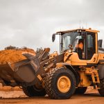 yellow and black heavy equipment on brown field during daytime